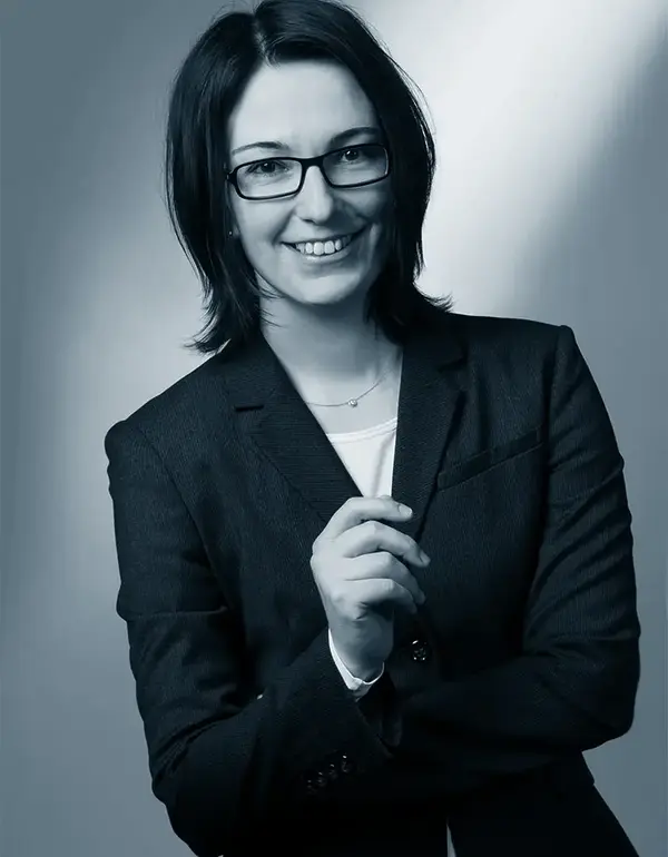 Eine Anwältin Frau Bernauer lächelt in die Kamera, verkörpert Kompetenz in Familienrecht bei der Kanzlei Müller & Koll.